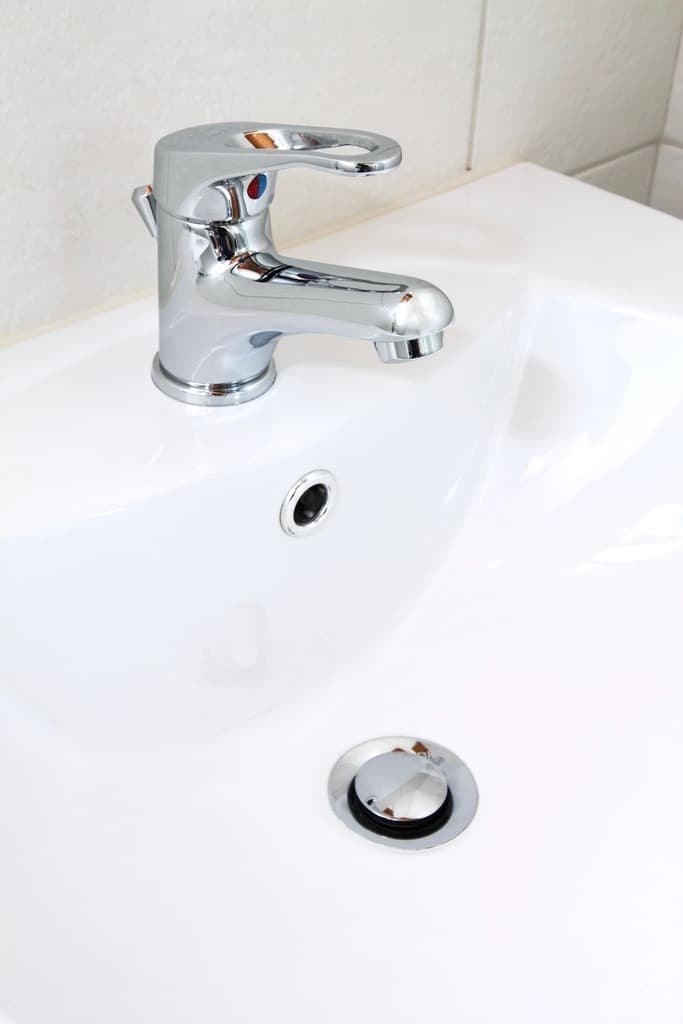 Mitigeur chromé sur un lavabo blanc